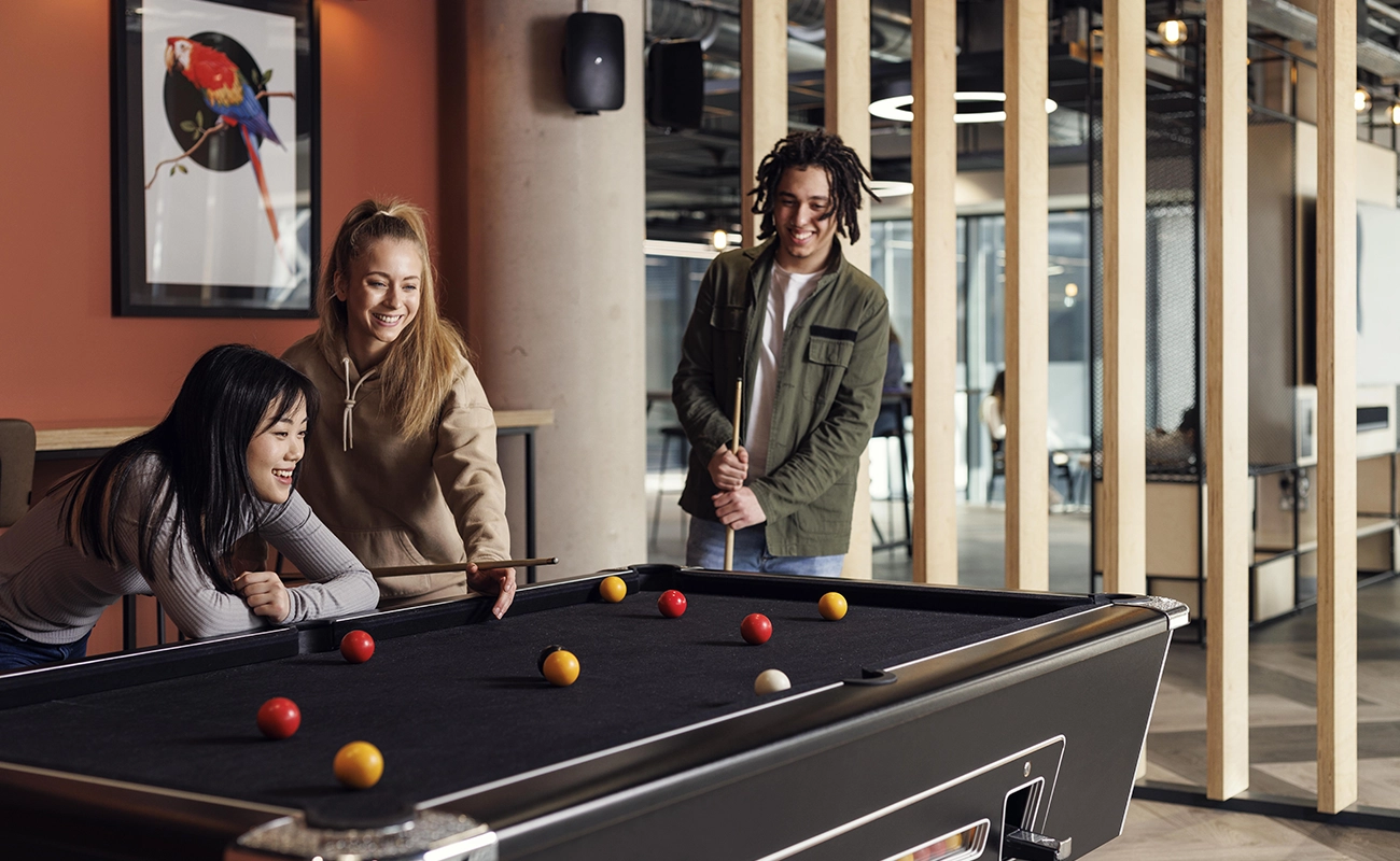 Students playing pool in the common area