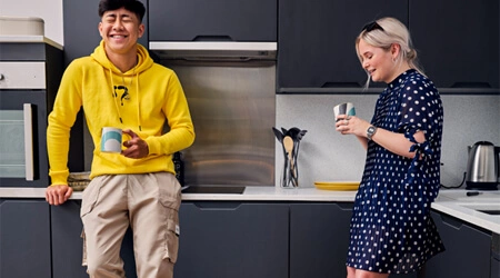 Two students laughing in their shared kitchen