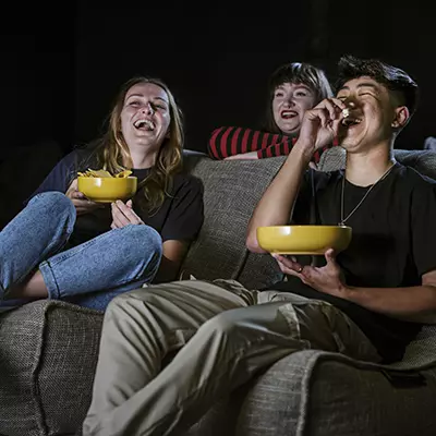 Students in a cinema room eating popcorn