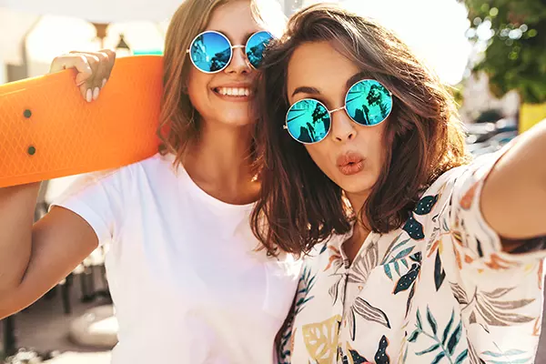 Two girls posing with a skateboard