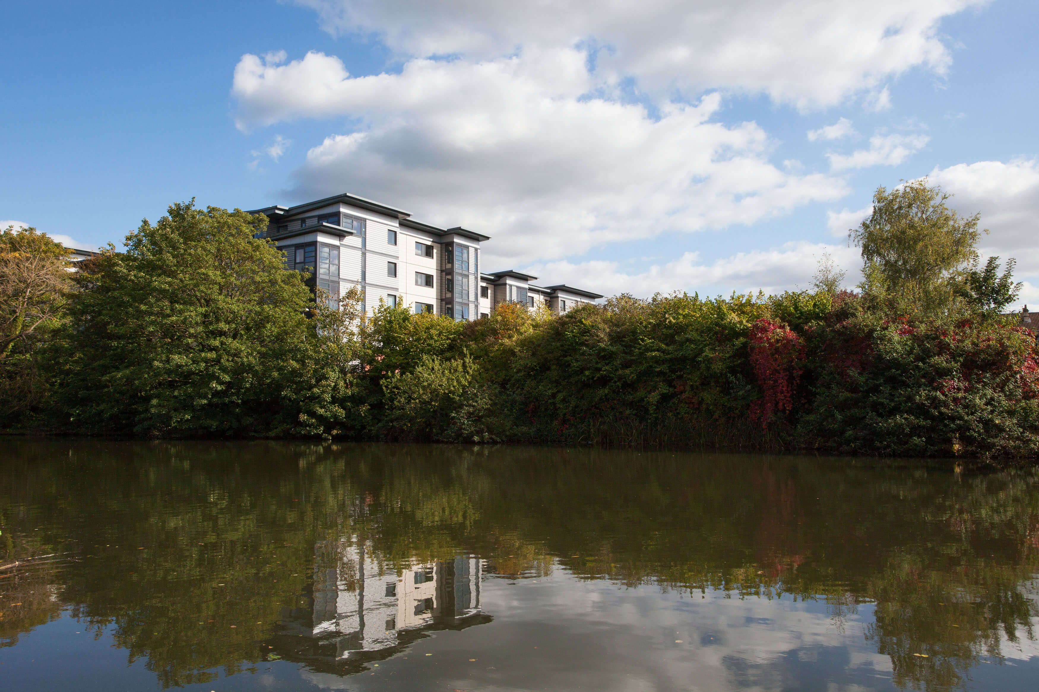 River and woodland surrounding building