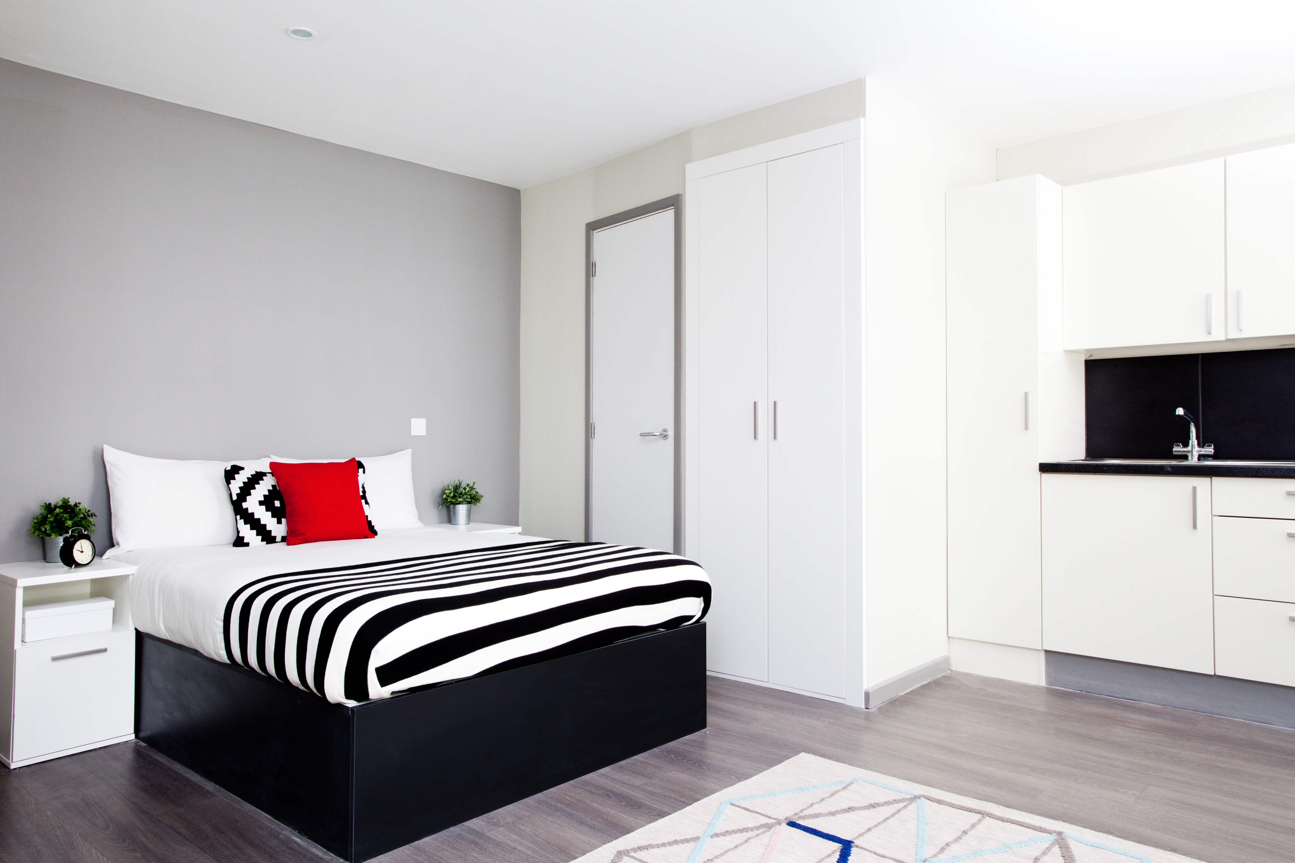 Bed next to a kitchen in a studio