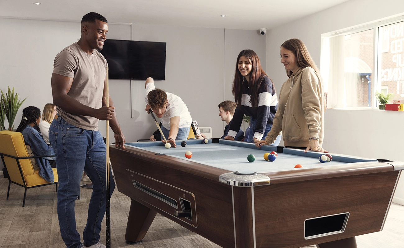 Students playing pool in the common room