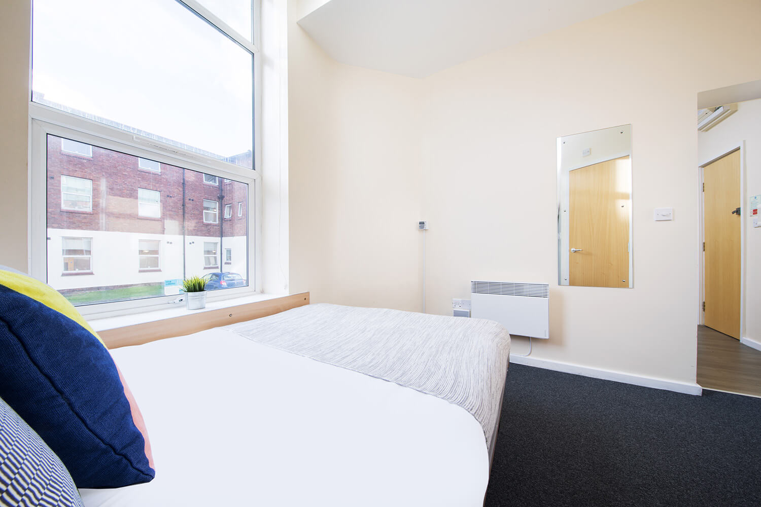 Student accommodation studio bed next to window in Liverpool
