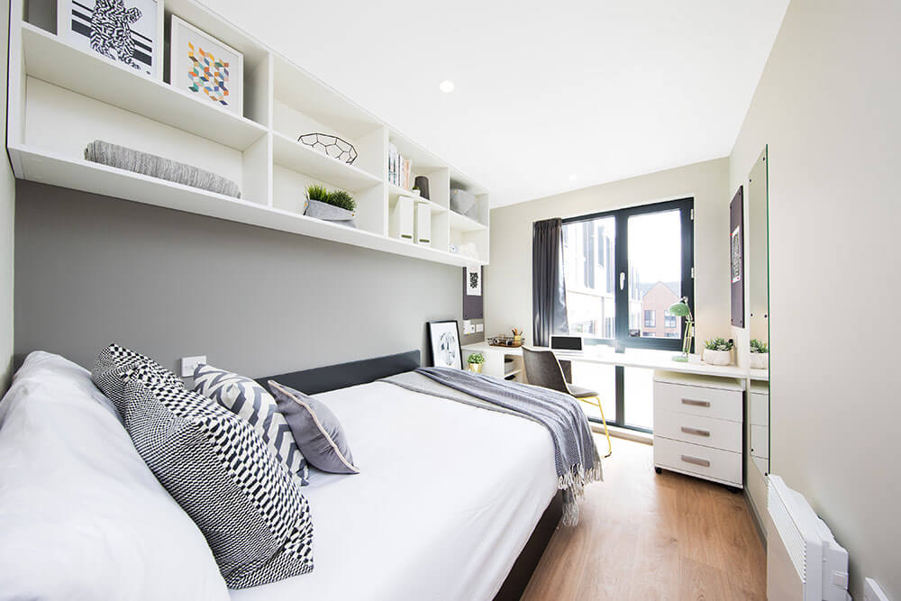 Student accommodation bedroom with a bed, shelves and desk